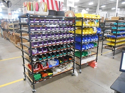 Color coded storage bins on a mobile flex craft shelving unit.