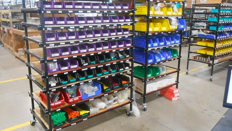 Flex Craft colored coded storage bins with labels organized on a Flex Craft Rack Cart.