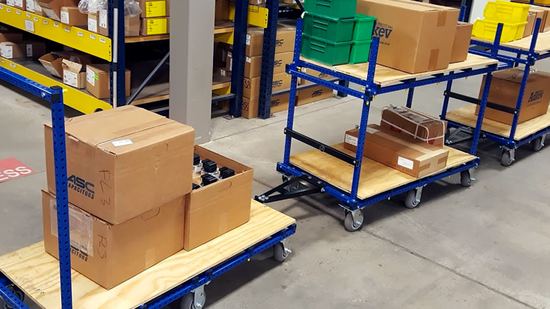 Flex Craft Towable Tugger Carts pulling boxes of product.