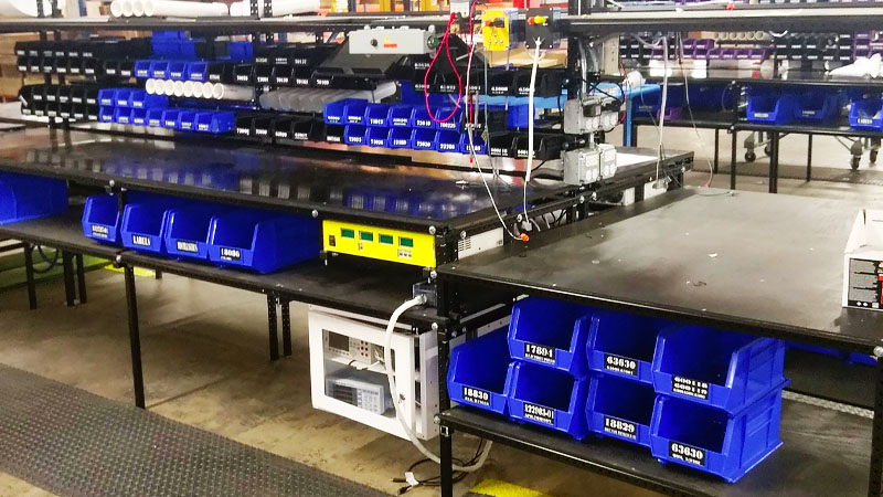 A manufacturing workstation with storage and rack shelving made with Flex Craft.